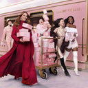 Lancôme La Vie Est Belle L'Elixir L'eau De Parfum 50ml Giftset campaign with Julia Roberts and models holding pink gift boxes in front of a pink train car.