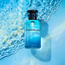 BEAUTE KNOWS Blue perfume bottle labeled 'Afternoon Swim' by Louis Vuitton on water with sunlight.