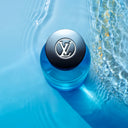 BEAUTE KNOWS top view of Louis Vuitton Afternoon Swim Eau De Parfum 100ml perfume bottle. a black lid featuring LV logo, set against a blue water background.