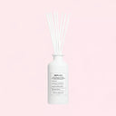 White Maison Margiela Replica By the Fireplace Scented Diffuser 185ml diffuser bottle with reeds on a light pink background