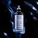 BEAUTE KNOWS Maison Margiela Replica Celestial Whisper Perfume bottle with blue smoke effects on a dark background