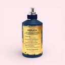 Blue and yellow Maison Margiela Replica Jazz Club Eau De Toilette - Limited Edition 100ml bottle with label on a light pink background