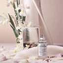 Maison Margiela Replica Lazy Sun Morning Eau de Toilette 100ml perfume bottle with flowers and a vase in the background