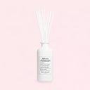White Maison Margiela Replica Lazy Sunday Scented Diffuser 185ml diffuser bottle with reeds on a light pink background