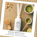 Maison Margiela Replica Matcha Meditation Scented Diffuser 185ml with matcha powder, whisk, and ingredients on a woven mat.
