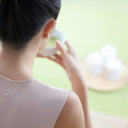 Person drinking matcha tea with a blurred background