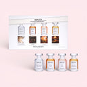 Set of Maison Margiela Replica mini perfume bottles with packaging on a pink background