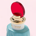 close up of Miu Miu Eau de Parfum 50ml perfume bottle with red cap on a light pink background