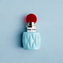 Miu Miu Eau de Parfum 50ml perfume bottle with a red cap on a light blue background