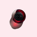 birdeye view of  N°1 DE CHANEL L'EAU ROUGE REVITALISING FRAGRANCE MIST bottle on a light pink background