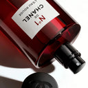 N°1 DE CHANEL L'EAU ROUGE REVITALISING FRAGRANCE MIST bottle with red glass and black cap on a white background