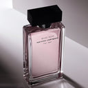 Perfume bottle of Narciso Rodriguez Musc Noir For Her on a reflective surface with a neutral background
