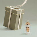 Gift box with a ribbon and a Penhaligon's Artemisia Eau de Parfum 100ml bottle on a light gray background