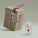 Gift box with a pink ribbon and a Fenwaligont Penhaligon's Elisabethan Rose Eau de Parfum 100ml perfume bottle on a light gray background