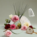 Decorative arrangement of flowers with a shell and small mirrors on a light background