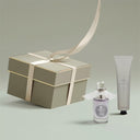 Gift box with a ribbon, perfume bottle, and tube of Penhaligon's Luna Hand Cream 75ml on a light gray background
