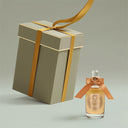Penhaligon's Solaris Eau de Parfum 100ml perfume bottle with a gold ribbon next to a matching gift box on a light gray background