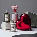 PENHALIGON's The Favourite skincare and fragrance products and a red heart-shaped object on a gray background