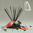 Incense sticks with grapefruit slices, coffee beans, and butterflies on a neutral background