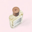 top side angle view of Ralph Lauren Polo Earth Eau de Toilette 40ml perfume bottle with wooden cap on a light pink background