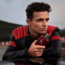 F1 Driver Lando Norris holding a red Ralph Lauren Polo Red Parfum 125ml perfume bottle with a blurred background