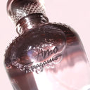 Close-up of a Salvatore Ferragamo Amo Eau de Parfum 100ml perfume bottle with a pinkish hue.