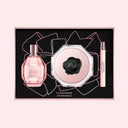 Viktor & Rolf Flowerbomb Eau De Parfum Gift Set including a 100ml bottle, a travel sized penspray and a 200ml body cream on a black background with pink accents