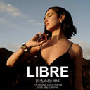 Woman holding a YSL Libre perfume bottle with a scenic background