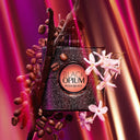 YSL Yves Saint Laurent Black Opium Eau de Parfum 50ml perfume bottle with coffee beans and flowers on a pink and purple background