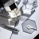 YSL Yves Saint Laurent L'Homme Eau de Toilette 100ml perfume bottle with a key, water glass and pen on a light surface