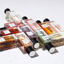 Rows of perfume bottles from YSL YVes Saint Laurent's Le Vestiaire des Parfums with colored liquids on a white background