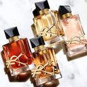 Four Yves Saint Laurent Libre range  perfume bottles with gold accents on a marble surface