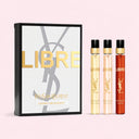 YSL Libre perfume discovery set with three travel sized pen spray bottles and a box on a pink background