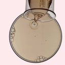 BEAUTE KNOWS Aesop B & Tea Balancing Toner liquid being poured into a glass beaker, showing its clear, light texture.
