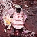 BEAUTE KNOWS Louis Vuitton Attrape-Rêves eau de parfum in a glass bottle surrounded by pink flowers on wet stone.
