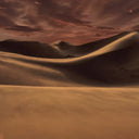 BEAUTE KNOWS Louis Vuitton Ombre Nomade desert landscape at dusk with golden dunes and a dramatic dark red sky