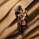 BEAUTE KNOWS Louis Vuitton Ombre Nomade oud wood, incense, and resin on desert sand, evoking a smoky, mystical scent.