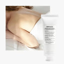BEAUTE KNOWS Maison Margiela REPLICA Lazy Sunday Morning hand cream tube next to a person resting in white bed sheets