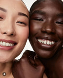 Two people with smiling faces, one with light skin and the other with dark skin, on a white background.